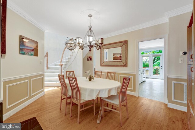 8162 Madrillon Ct, Vienna, VA 22182 - dining area with a chandelier, stairway, a decorative wall, crown molding, and wainscoting