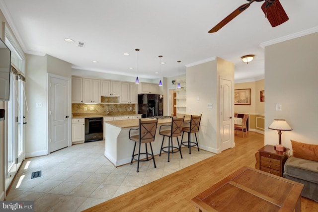 8162 Madrillon Ct, Vienna, VA 22182 - kitchen with black appliances, a ceiling fan, a kitchen bar, backsplash, and crown molding