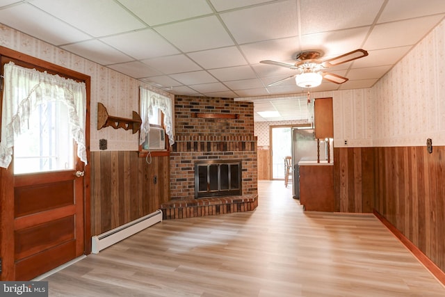 175 Dellville Rd, Duncannon, PA 17020 - unfurnished living room featuring baseboard heating, wainscoting, wallpapered walls, a ceiling fan, and wood walls