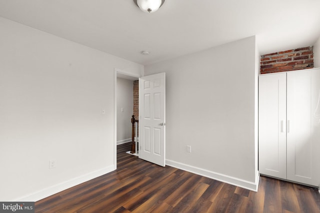 123 E Cross St, Baltimore, MD 21230 - unfurnished bedroom featuring dark wood-style flooring and baseboards