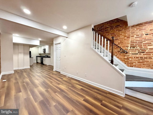 123 E Cross St, Baltimore, MD 21230 - unfurnished living room featuring stairs, dark wood finished floors, recessed lighting, and brick wall