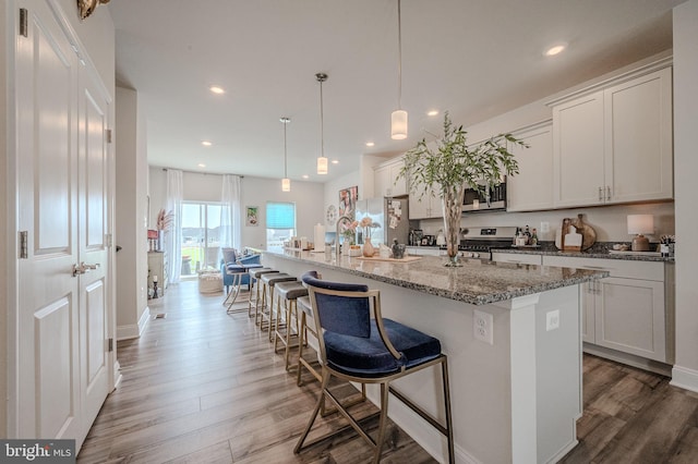 35354 Wright Way, Millsboro, DE 19966 - kitchen with stainless steel appliances, wood finished floors, recessed lighting, a large island with sink, and a breakfast bar