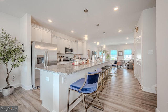 35354 Wright Way, Millsboro, DE 19966 - kitchen with stainless steel appliances, light wood finished floors, a large island with sink, recessed lighting, and white cabinetry