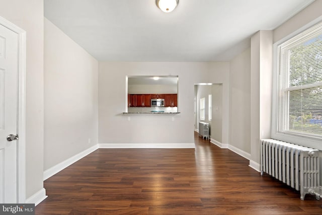 223 Hudson St, Gloucester City, NJ 08030 - unfurnished living room featuring radiator, plenty of natural light, and dark wood-style flooring