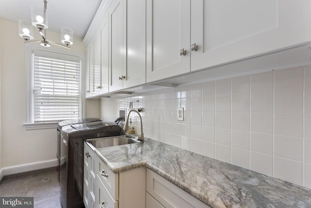 4600 Atlantic Ave, Atlantic City, NJ 08401 - kitchen with decorative backsplash, white cabinetry, washing machine and dryer, a chandelier, and light stone counters