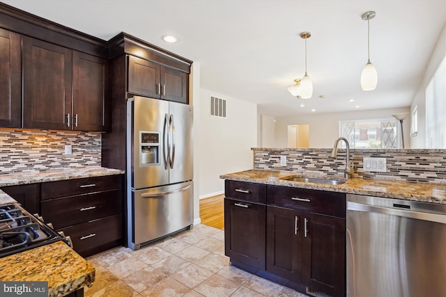 5100 12th St NE, Washington, DC 20011 - kitchen with stainless steel appliances, tasteful backsplash, decorative light fixtures, light stone countertops, and recessed lighting