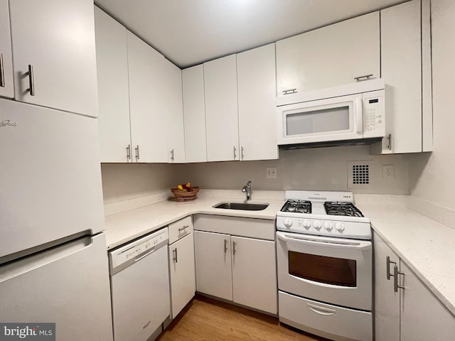 2939 Van Ness St NW Unit 743, Washington, DC 20008 - kitchen featuring white appliances, light countertops, light wood-type flooring, and white cabinets