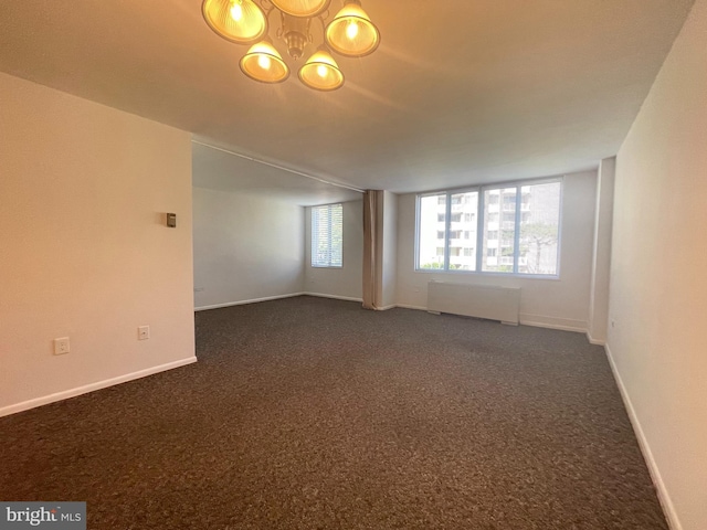 2939 Van Ness St NW Unit 743, Washington, DC 20008 - spare room with radiator heating unit, dark carpet, and a chandelier
