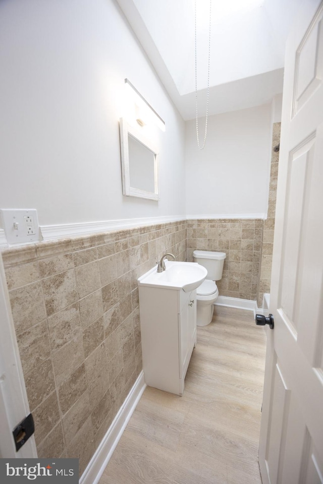 7127 Woolston Ave, Philadelphia, PA 19138 - bathroom with tile walls, vanity, wood finished floors, and a wainscoted wall