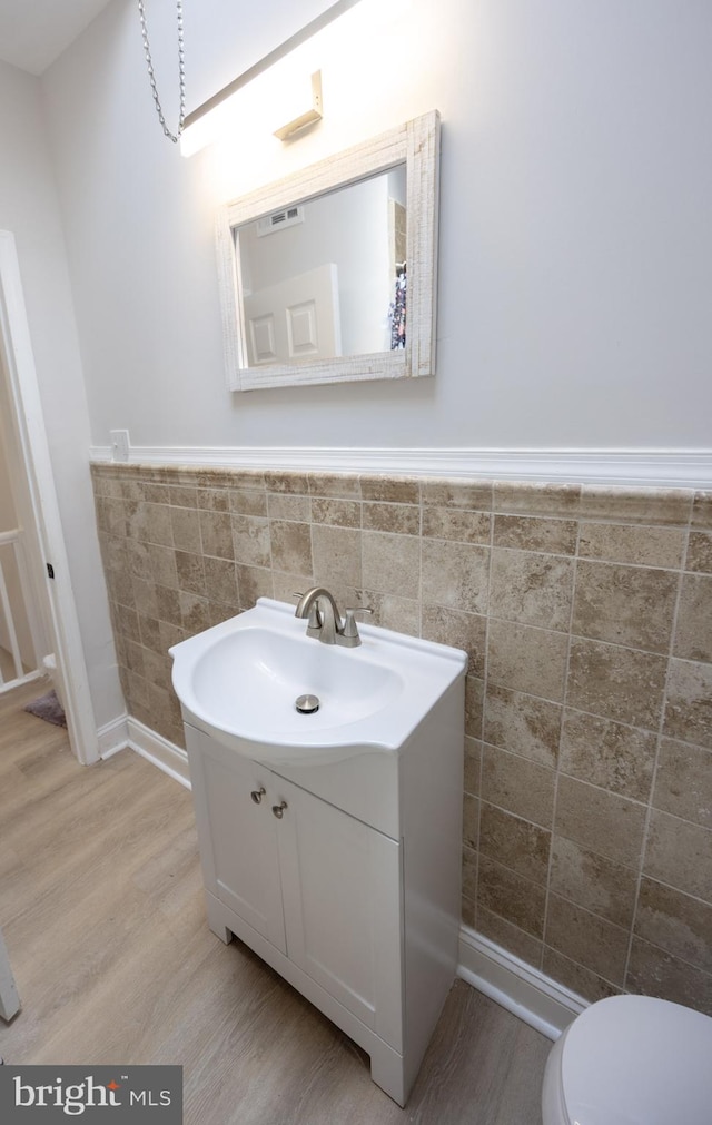 7127 Woolston Ave, Philadelphia, PA 19138 - bathroom with vanity, tile walls, wainscoting, and wood finished floors