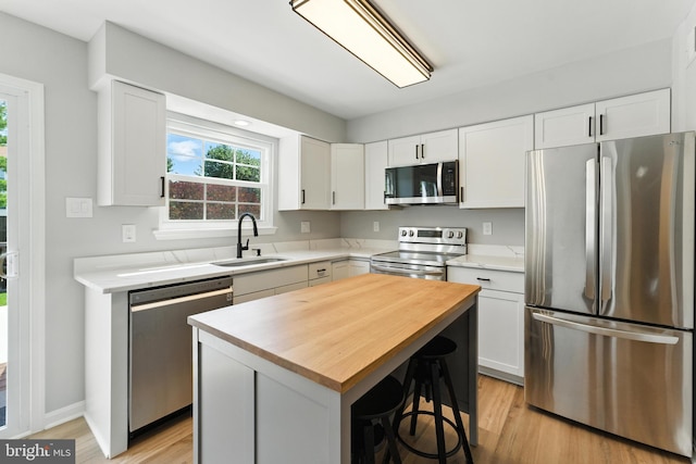 3159 Benton Square Dr, Olney, MD 20832 - kitchen featuring appliances with stainless steel finishes, butcher block countertops, light wood-style floors, and white cabinets