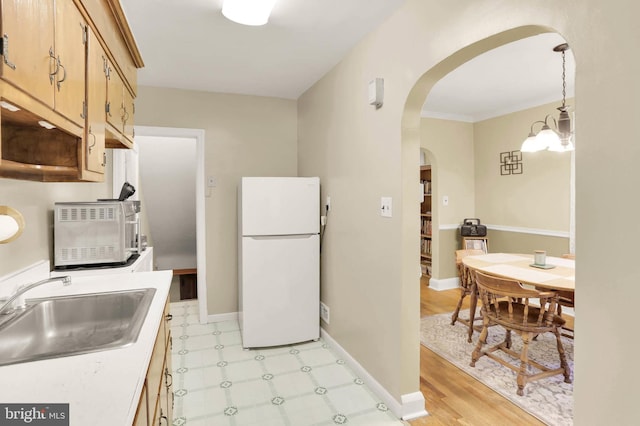 5947 Lillyan Ave, Baltimore, MD 21206 - kitchen with freestanding refrigerator, arched walkways, light countertops, light flooring, and a chandelier