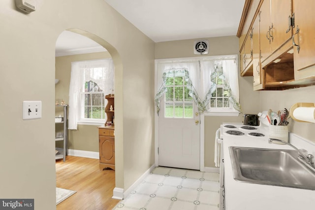 5947 Lillyan Ave, Baltimore, MD 21206 - kitchen with arched walkways, light countertops, and light wood finished floors