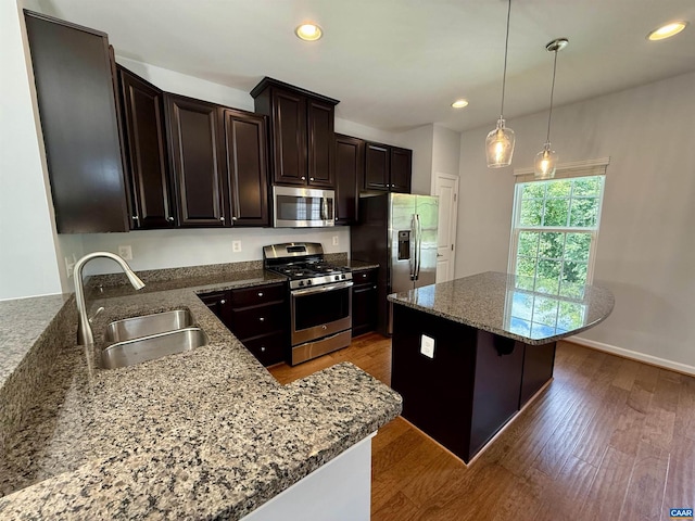 2176 Whispering Hollow Ln, Charlottesville, VA 22911 - kitchen featuring appliances with stainless steel finishes, a kitchen island, wood finished floors, recessed lighting, and stone counters
