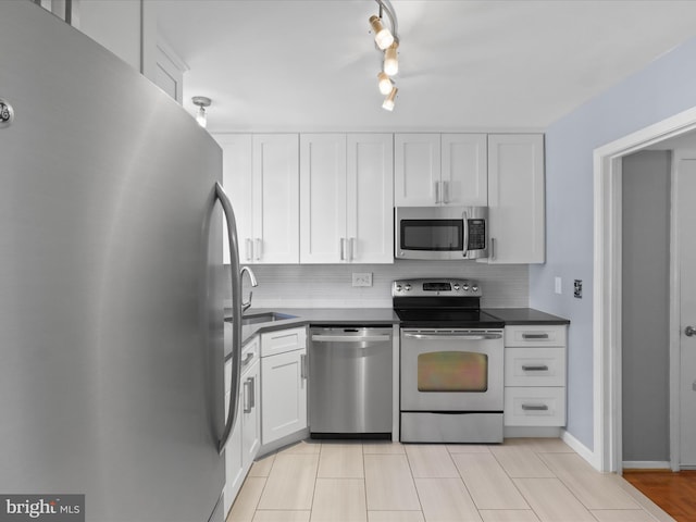 3390 Whipple Ct, Annandale, VA 22003 - kitchen featuring stainless steel appliances, dark countertops, tasteful backsplash, and white cabinets