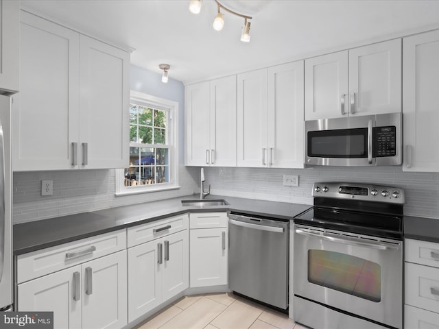 3390 Whipple Ct, Annandale, VA 22003 - kitchen featuring stainless steel appliances, dark countertops, white cabinets, tasteful backsplash, and light tile patterned floors