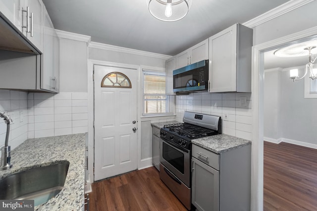 1112 Serrill Ave, Lansdowne, PA 19050 - kitchen featuring appliances with stainless steel finishes, dark wood-type flooring, decorative backsplash, light stone counters, and ornamental molding