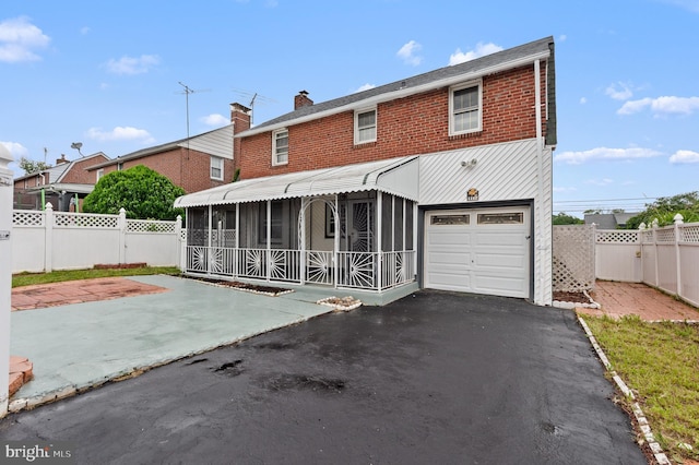 1112 Serrill Ave, Lansdowne, PA 19050 - view of front of property featuring a chimney, a garage, driveway, and a sunroom