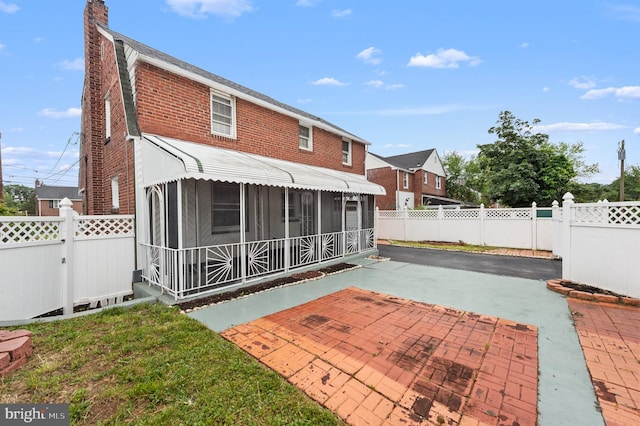 1112 Serrill Ave, Lansdowne, PA 19050 - back of house with a patio area, a fenced backyard, a chimney, brick siding, and a sunroom