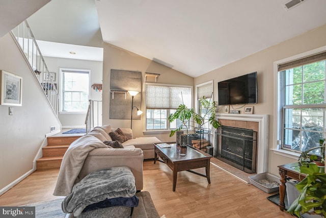 19901 Drexel Hill Cir, Gaithersburg, MD 20886 - living area featuring stairs, light wood-type flooring, vaulted ceiling, and a tiled fireplace
