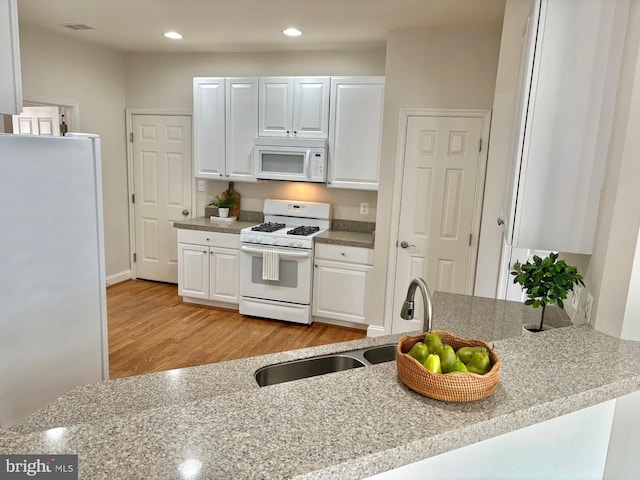 13854 Cinch Ln, Gainesville, VA 20155 - kitchen with white appliances, light wood-type flooring, white cabinets, recessed lighting, and light stone counters