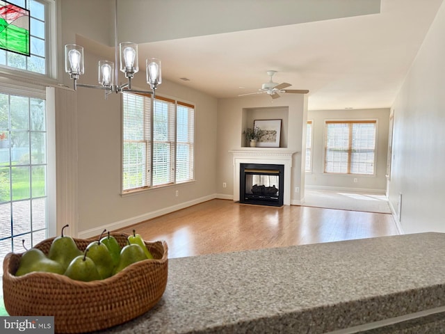 13854 Cinch Ln, Gainesville, VA 20155 - living area with wood finished floors, a multi sided fireplace, a ceiling fan, and a chandelier