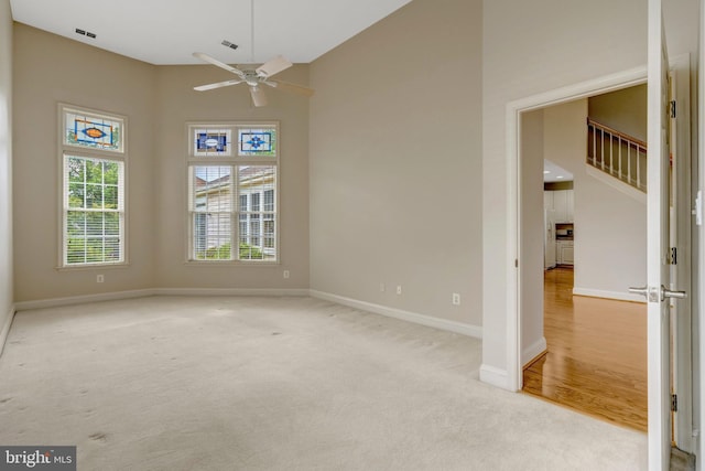 13854 Cinch Ln, Gainesville, VA 20155 - carpeted spare room with a ceiling fan, a towering ceiling, and stairs