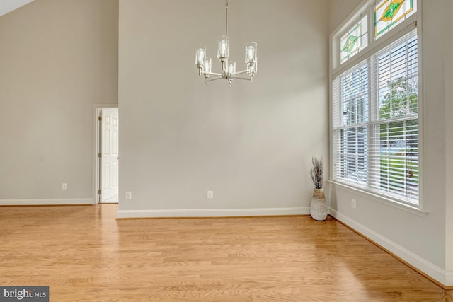 13854 Cinch Ln, Gainesville, VA 20155 - spare room featuring light wood-type flooring, a chandelier, and a towering ceiling