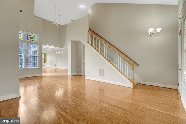 13854 Cinch Ln, Gainesville, VA 20155 - unfurnished living room with a chandelier, a high ceiling, stairway, and wood finished floors