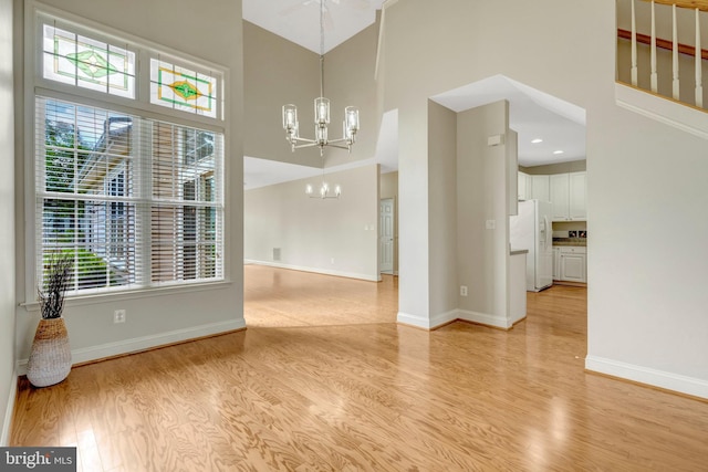 13854 Cinch Ln, Gainesville, VA 20155 - unfurnished dining area featuring a high ceiling, a chandelier, and light wood-style flooring