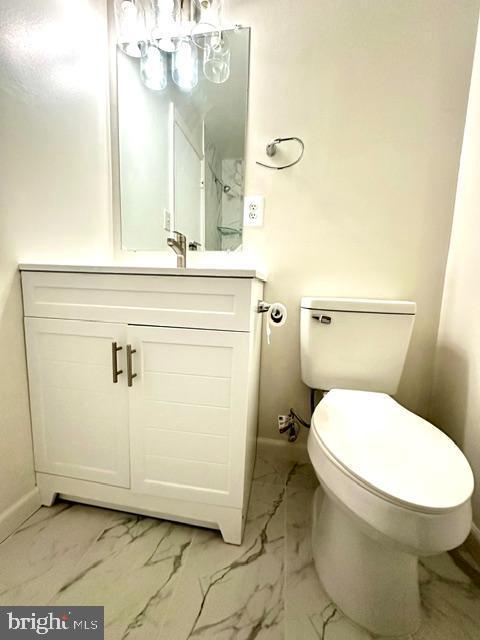 7851 W Point Ct, Manassas, VA 20109 - half bathroom featuring vanity, marble look tiles, and a chandelier