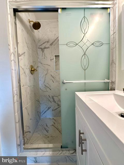 7851 W Point Ct, Manassas, VA 20109 - bathroom with a marble finish shower, vanity, and marble look tiles