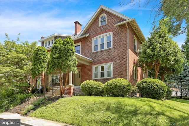 23 Trebor Pl, Reading, PA 19610 - view of front facade featuring brick siding, a front yard, and a chimney