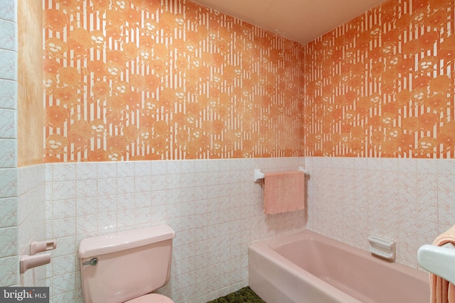 418 1st Ave, Clearfield, PA 16830 - bathroom with wallpapered walls, tile walls, a wainscoted wall, and a bath
