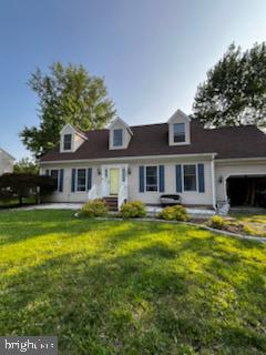 8535 Colony Cir, Easton, MD 21601 - cape cod-style house featuring an attached garage and a front lawn