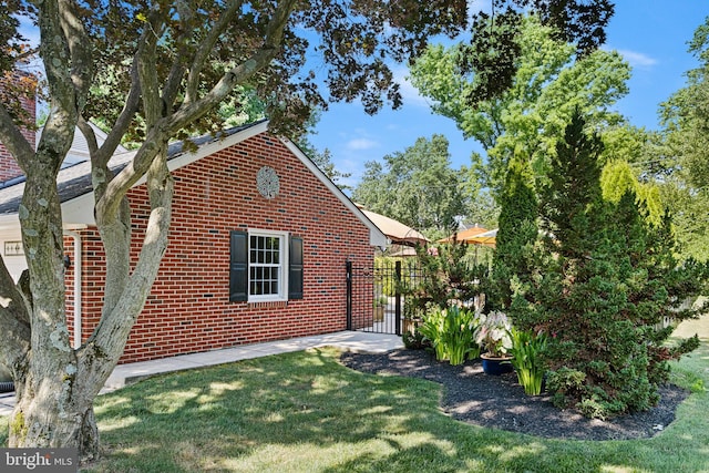1512 Marsh Rd, Wilmington, DE 19803 - view of side of property with brick siding, a gate, and a yard