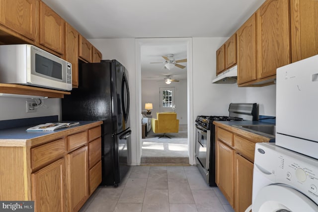 925 Barron Ave, Baltimore, MD 21221 - kitchen featuring white microwave, stainless steel range with gas stovetop, under cabinet range hood, a ceiling fan, and freestanding refrigerator
