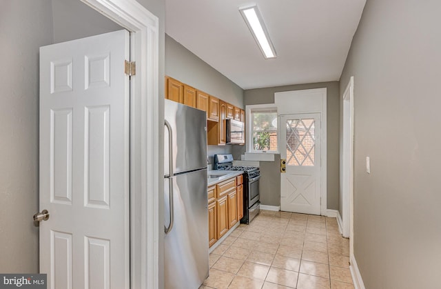 4352 Sheldon Ave, Baltimore, MD 21206 - kitchen featuring stainless steel appliances, light countertops, and light tile patterned flooring