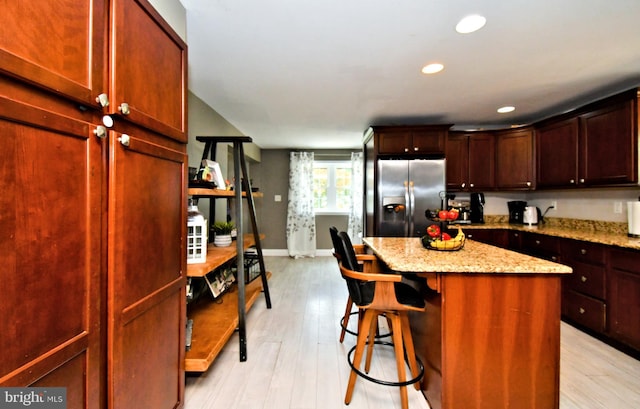 1437 Hilltop Rd, Pottstown, PA 19464 - kitchen featuring stainless steel fridge, a center island, a breakfast bar, light wood-type flooring, and light stone counters