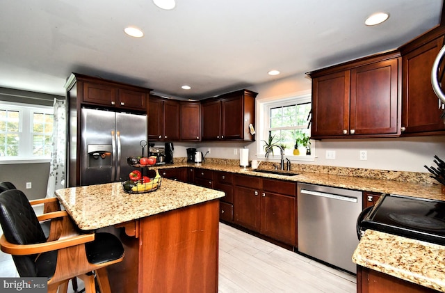 1437 Hilltop Rd, Pottstown, PA 19464 - kitchen featuring appliances with stainless steel finishes, a center island, recessed lighting, light stone countertops, and a kitchen bar