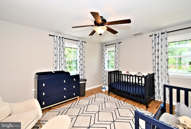 1437 Hilltop Rd, Pottstown, PA 19464 - bedroom with light wood-type flooring, a nursery area, and a ceiling fan