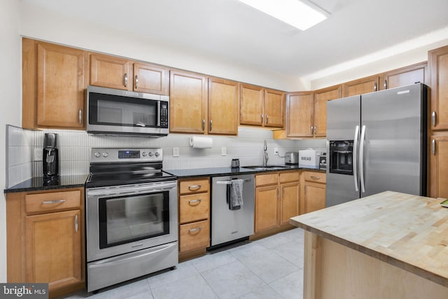 2121 Jamieson Ave Unit 707, Alexandria, VA 22314 - kitchen with appliances with stainless steel finishes, decorative backsplash, light tile patterned floors, and wood counters