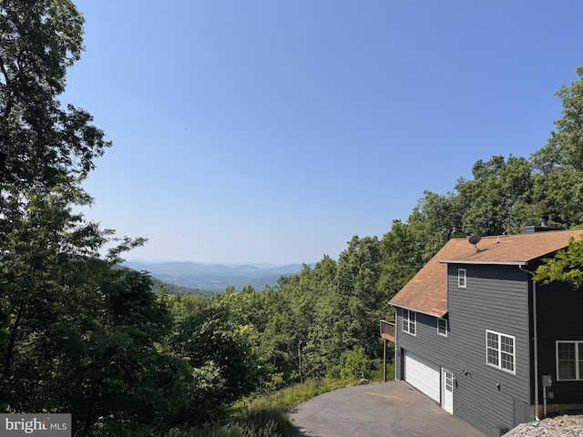 728 Shenandoah Valley Dr, Front Royal, VA 22630 - view of home's exterior with driveway, a garage, roof with shingles, and a view of trees