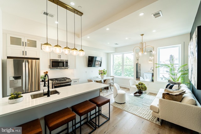 2517 Ontario Rd NW Unit Ph7, Washington, DC 20009 - kitchen with appliances with stainless steel finishes, glass insert cabinets, wood finished floors, a kitchen breakfast bar, and open floor plan