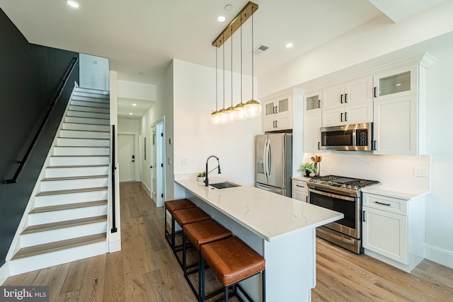 2517 Ontario Rd NW Unit Ph7, Washington, DC 20009 - kitchen with stainless steel appliances, light wood-style flooring, a breakfast bar, white cabinets, and recessed lighting