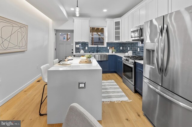 3306 E Lombard St, Baltimore, MD 21224 - kitchen featuring stainless steel appliances, blue cabinets, white cabinetry, backsplash, and light countertops