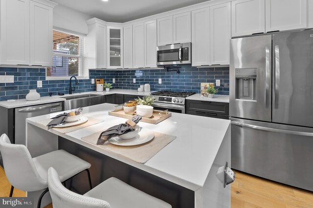 3306 E Lombard St, Baltimore, MD 21224 - kitchen featuring appliances with stainless steel finishes, light countertops, a kitchen breakfast bar, and white cabinets