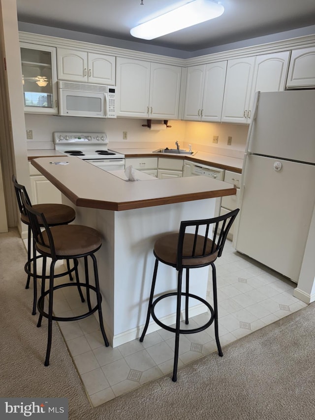 1103 S Schumaker Dr Unit C-300, Salisbury, MD 21804 - kitchen with white appliances, a breakfast bar area, light colored carpet, and white cabinets