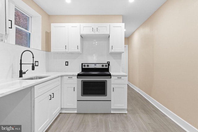2839 N 9th St, Philadelphia, PA 19133 - kitchen featuring stainless steel electric range oven, light wood-style floors, white cabinetry, tasteful backsplash, and recessed lighting