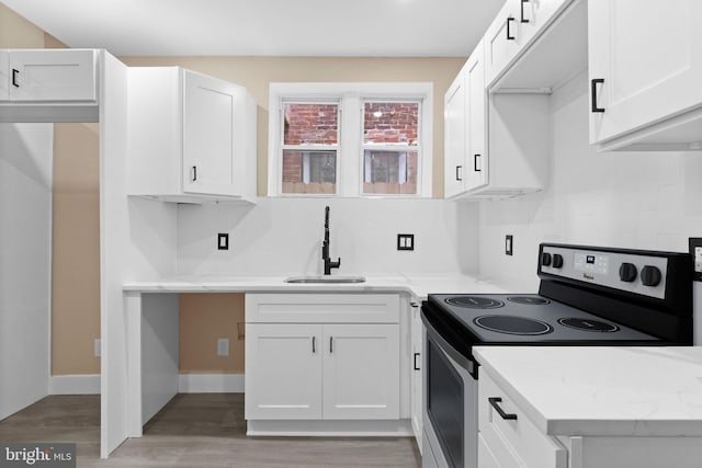 2839 N 9th St, Philadelphia, PA 19133 - kitchen featuring electric stove, light wood-type flooring, and white cabinetry